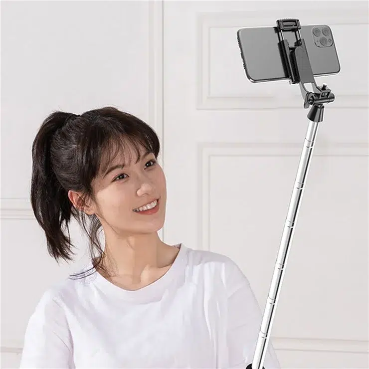 Mujer usando un palo selfie para hacerse una foto con su móvil.