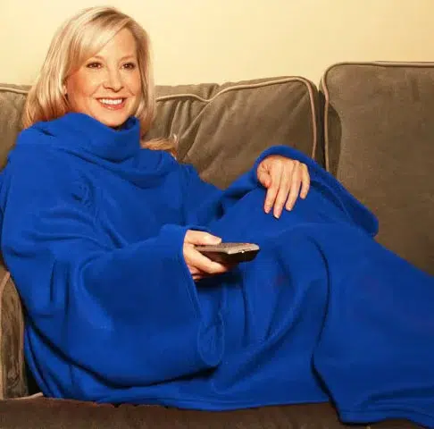 Mujer usando una manta con mangas Snuggie de color azul, también conocida como batamanta
