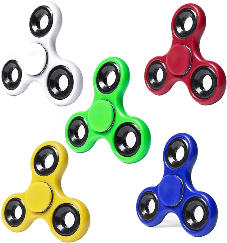 Cinco fidget spinners de colores blanco, verde, rojo, amarillo y azul sobre fondo blanco.